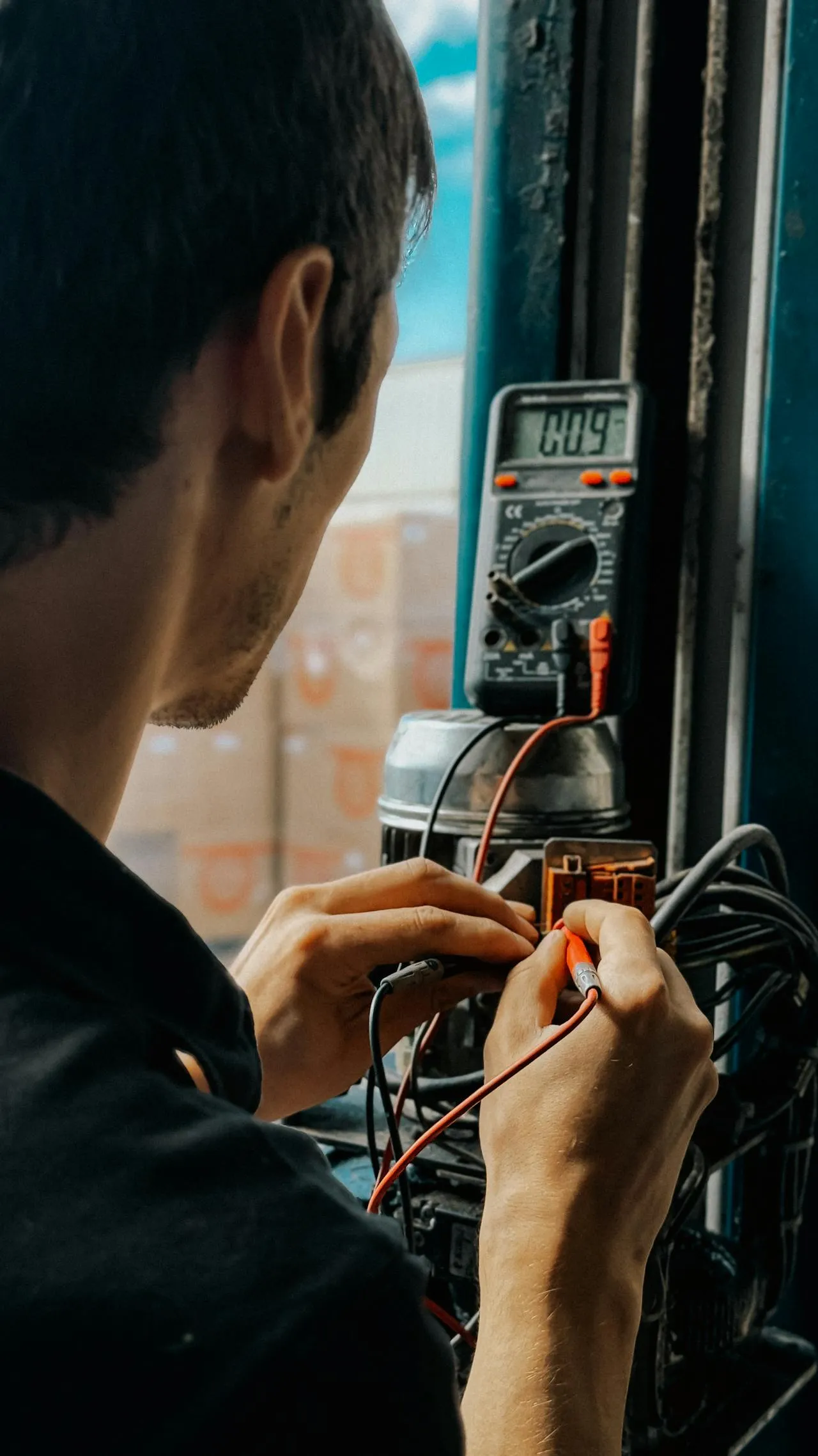 Electrician checking voltages with multimeter